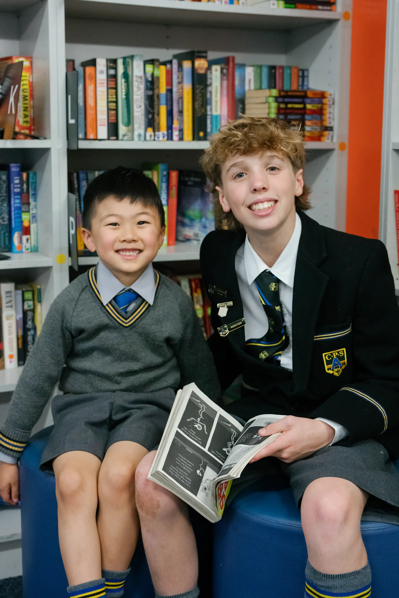 An older Coogee Prep boy reading with a younger buddy in the library