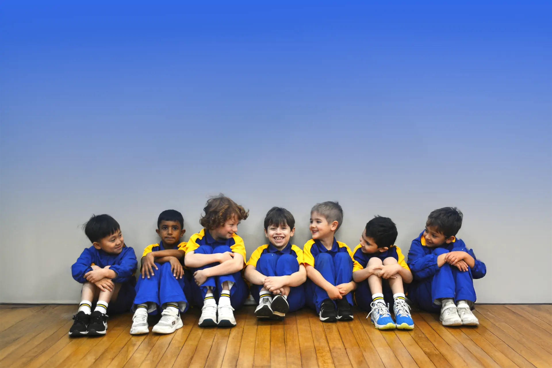 Kindergarten boys sitting in a row in the school hall