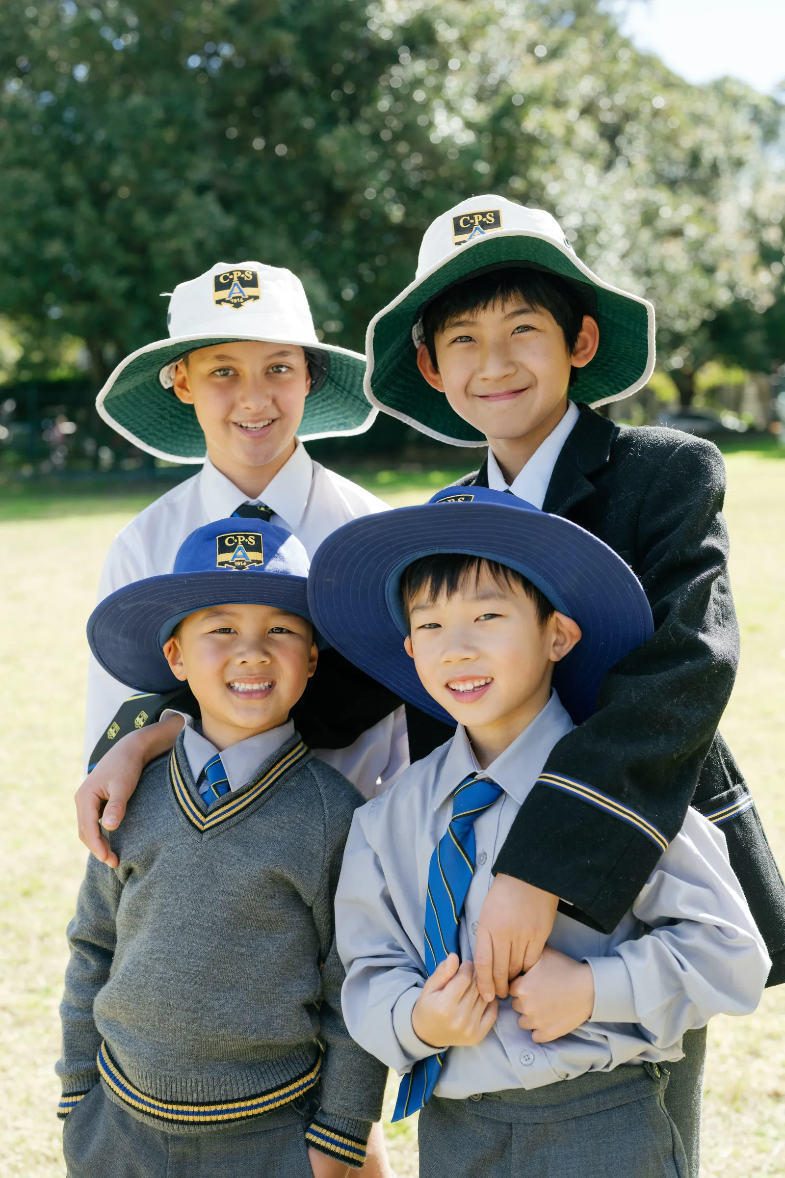 Four Coogee Prep boys together in their school hats