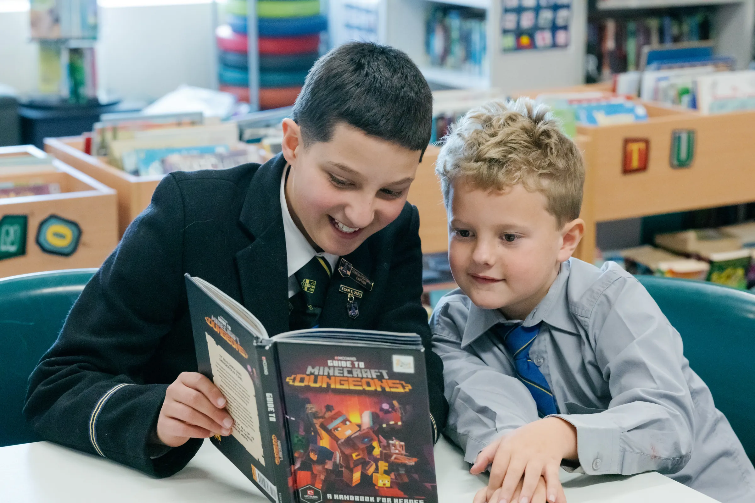 Two Coogee Prep boys looking at a book together in the library